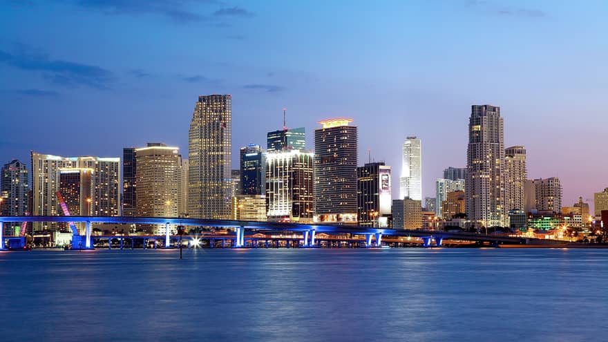Miami highrise buildings with lights along water at night