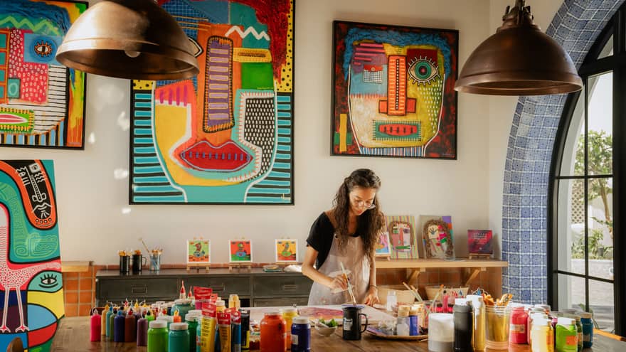 Woman paints in colourful art studio at luxury resort