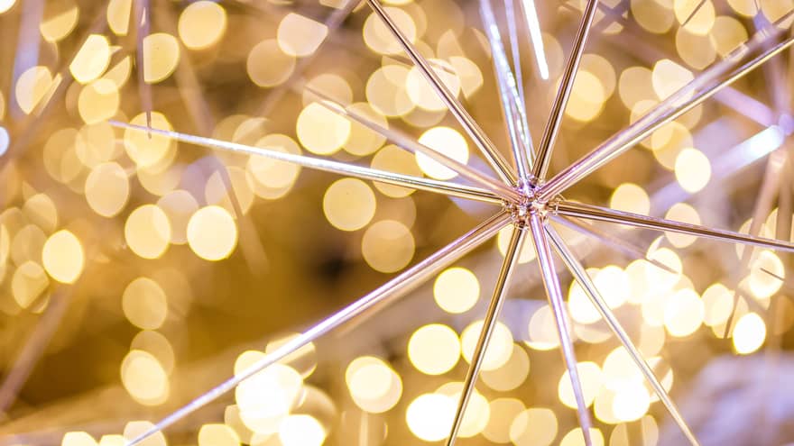 A pointy gold ornament surrounded by small yellow lights.