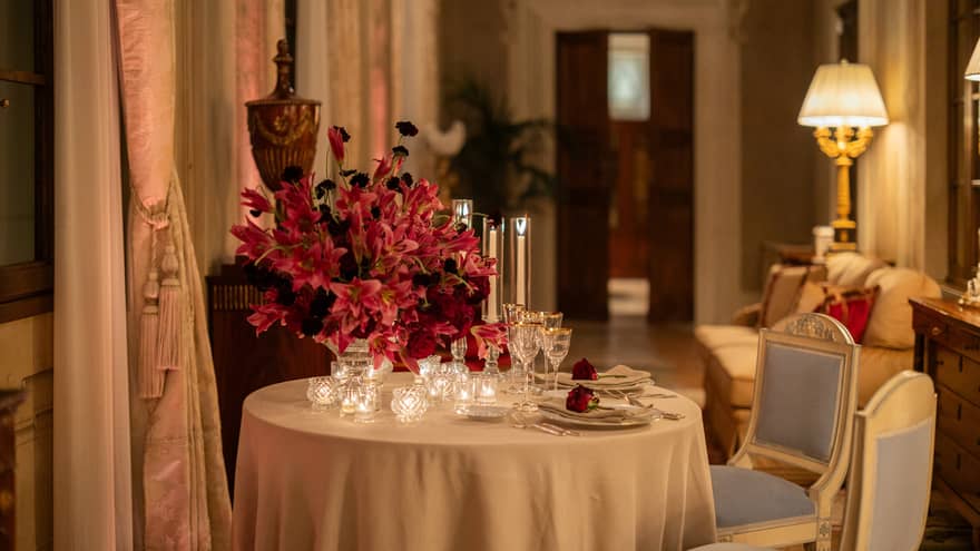 A table set for two in an elegant, softly lit interior space with opulent decor