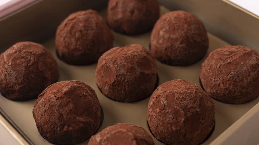 Nine dark chocolate truffles lined up in rows of three