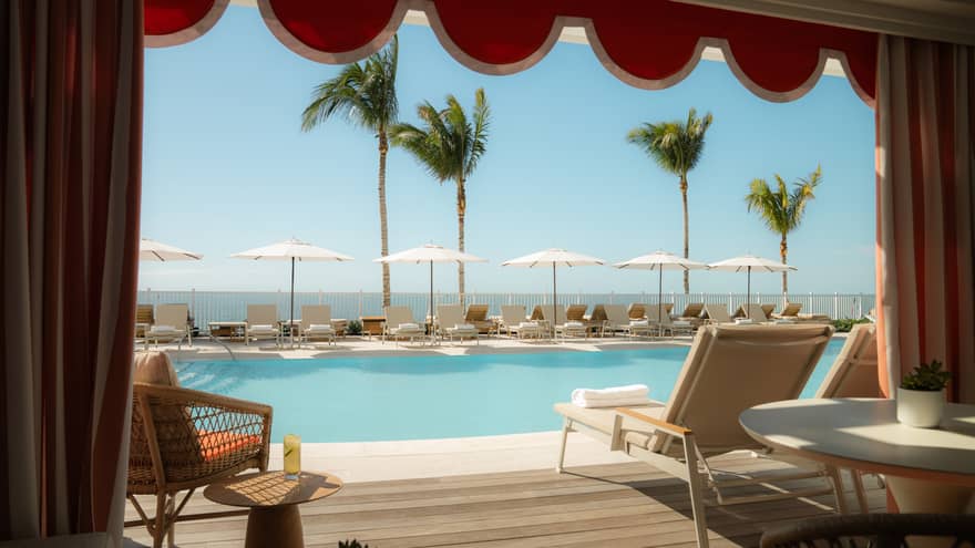View from within a poolside cabana looking out onto the water
