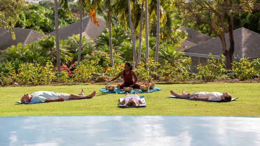 A group doing yoga and meditation outside.