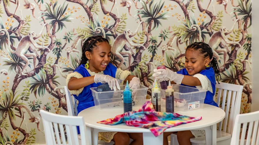 Two children sitting at a table and doing crafts