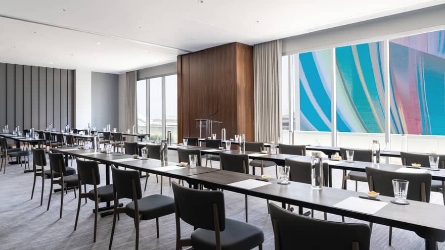 A large meeting room with long tables and large windows.
