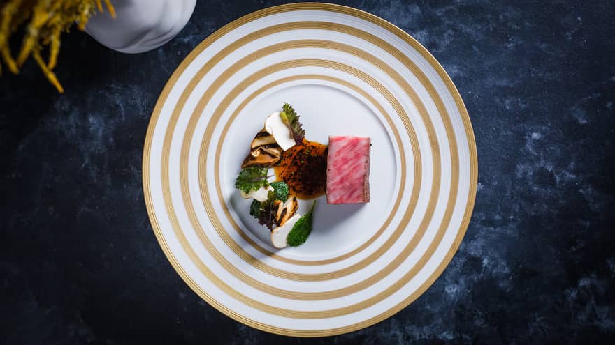 Colourful food on a white and beige plate.