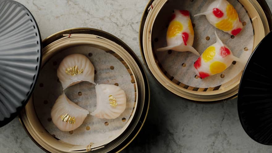 Aerial view of two different types of dim sum in steamer baskets