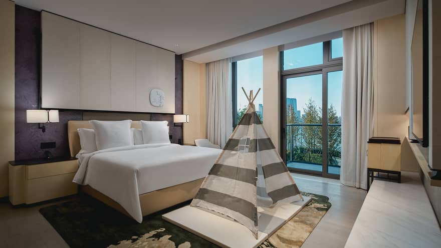 Luxury hotel suite bedroom with king bed and kids tent at Four Seasons Hotel Suzhou