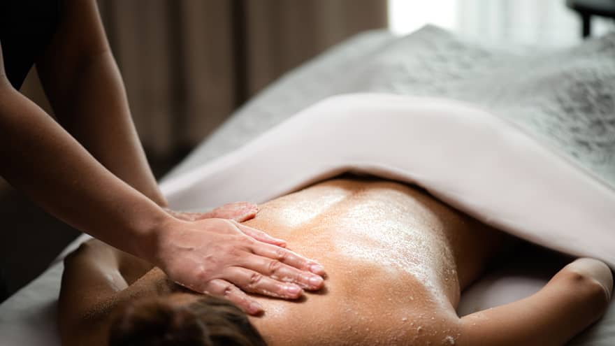 A woman being massaged by a spa staff member while lying down.