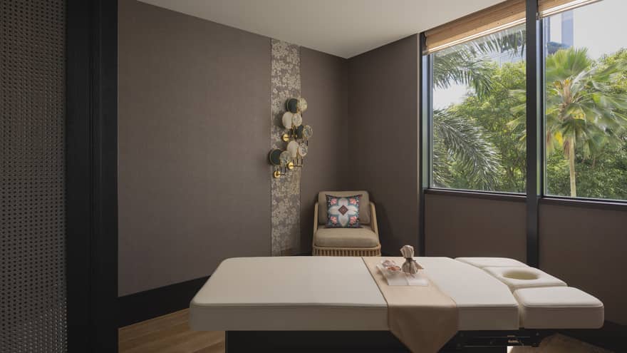 Massage table with a view of the jungle outside the window