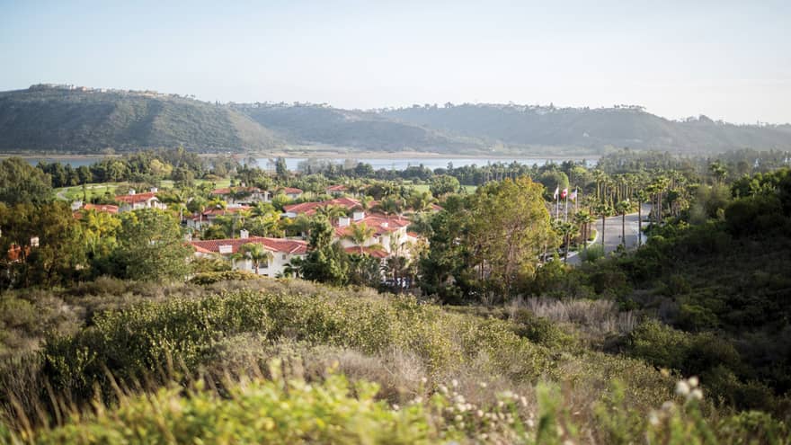 Aviara golf course grassy hills overlooking hotel, lagoon and mountains