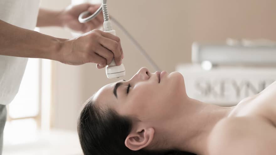 Spa attendant applies a facial to a guest