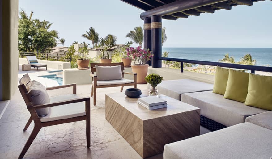 Covered, ocean-view outdoor lounge with sectional sofa and two chairs