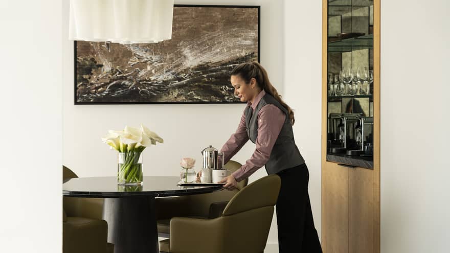 An employee delivers a tray with coffee to a suite