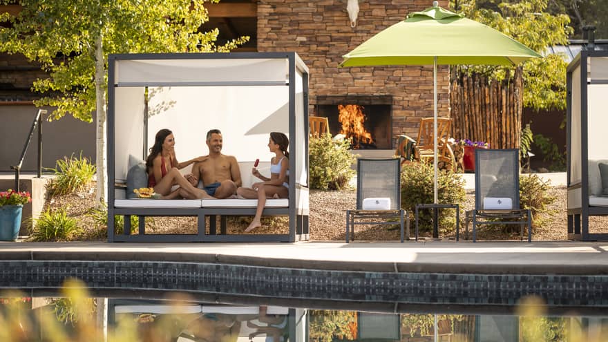 A family sitting in a cabana by the pool