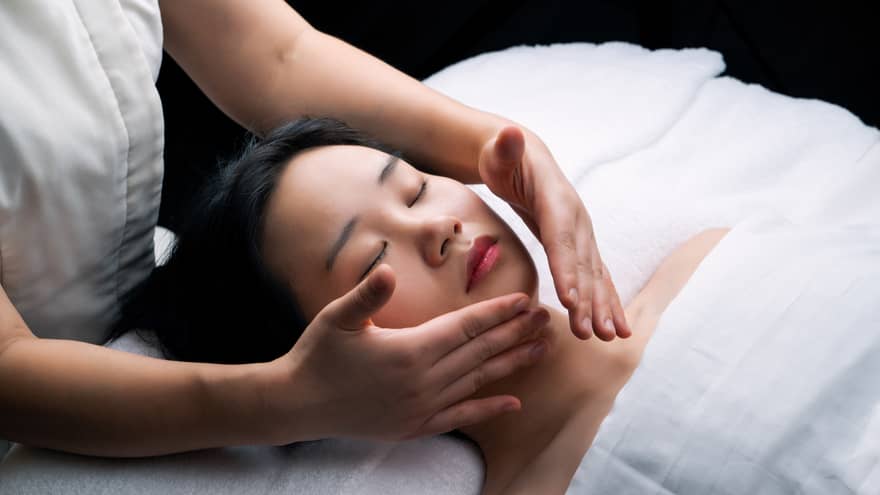 Guest laying on a spa table and getting a facial.