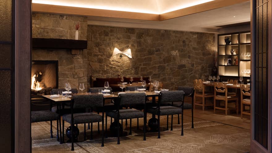 A warmly lit dining room featuring a stone accent wall.