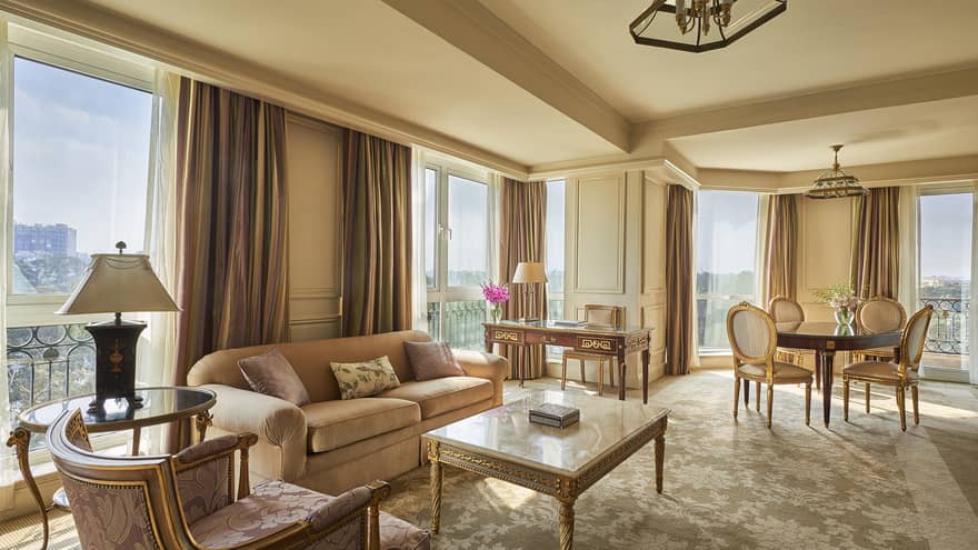 Diplomatic Suite corner living room with pink and cream-coloured sofas, carpets, rug and curtains