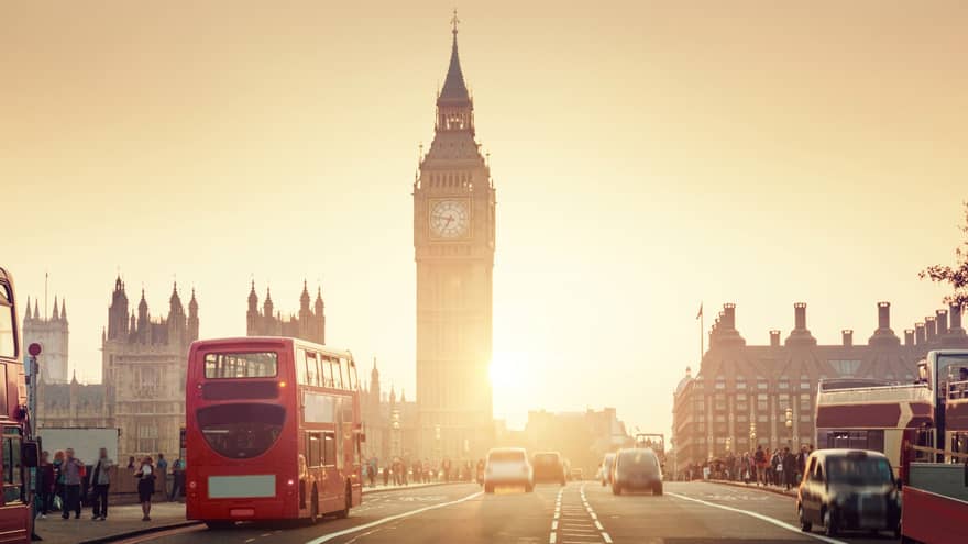 Street view of London at sunset, Big Ben tower and red double-decker bus in background
