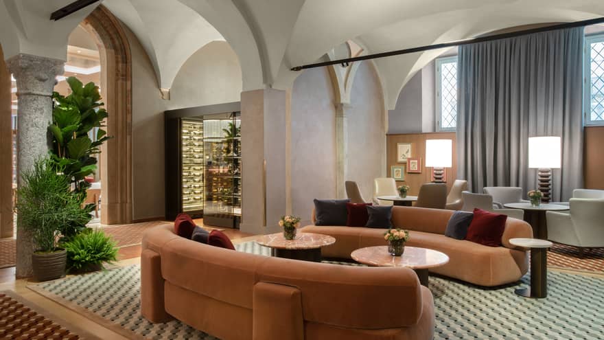 Lounge with two orange, velvet, curved sofas and checked floor