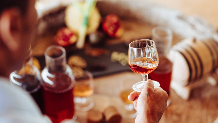 A person holding a clear glass of rum 