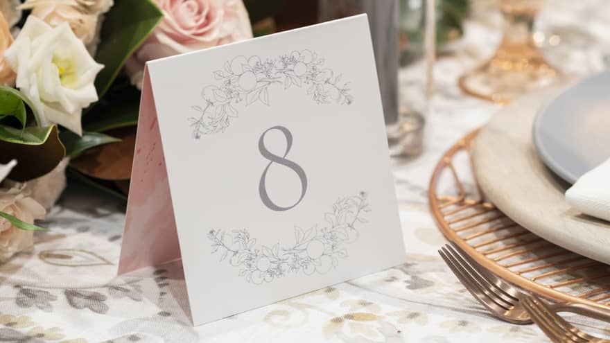 Wedding reception dining table, number 8 on place card, candles and roses
