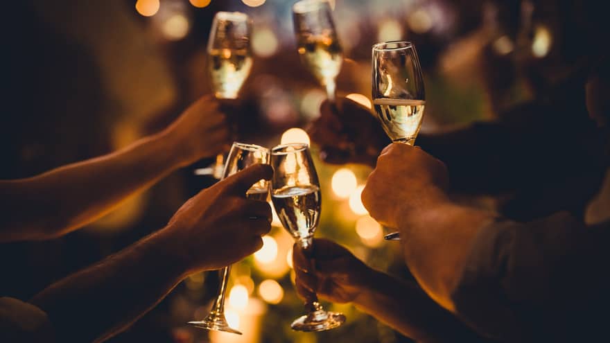 Numerous hands holding champagne flutes with champagne celebratory toast silhouettes