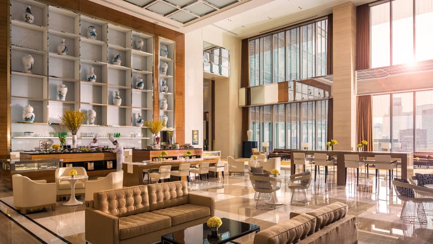 Large wall with blue and white ceramic vases over chefs at bar, bright modern dining lounge