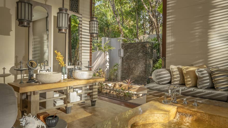 Large bathroom with natural materials, sofa and outdoor shower