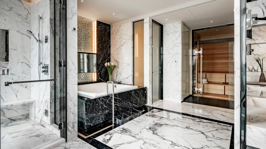 Presidential Suite full marble bathroom with white marble glass walk-in shower, black marble tub