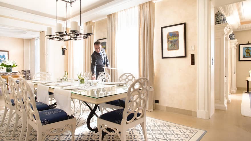 Hotel staff sets long table in bright Villa Rose-Pierre dining room