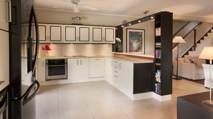 Residence Villa kitchen with black-and-white cupboards, shelves, white tile floors