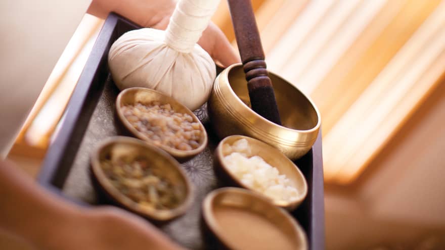 Tray with small brass bowls with spa lotions, massage oils, herbal poultice
