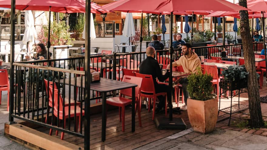 An outdoor eating area with white buildings around it.