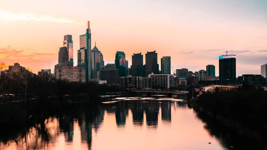 The sun sets on the Philadelphia skyline, reflected in the Schuylkill River