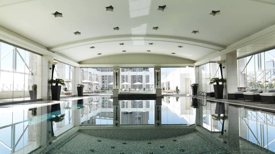 A long shot of a blue pool with mosaic tile.
