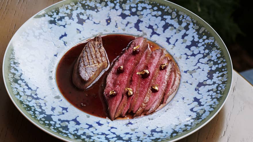 Sliced steak in a brown sauce.
