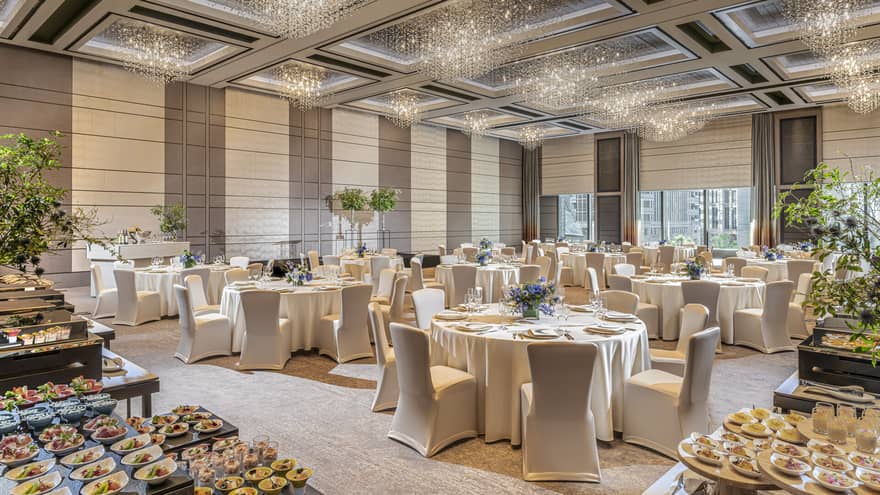 Grand Ballroom set up for a wedding with food, white linens and floral arrangements