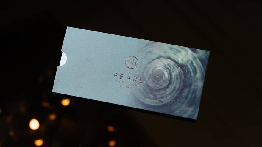 Light-blue metallic gift card for The Pearl Spa set on a black backdrop