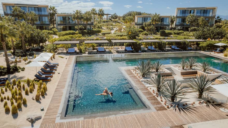 A couple stands in a large resort pool