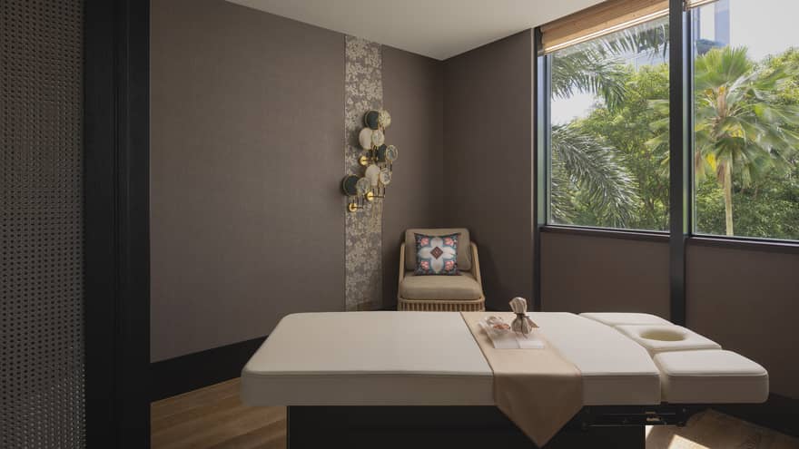 Massage table with a view of the jungle outside the window