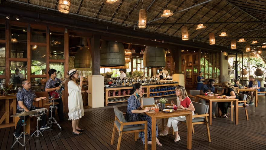 A live band performs at restaurant under thatched roof