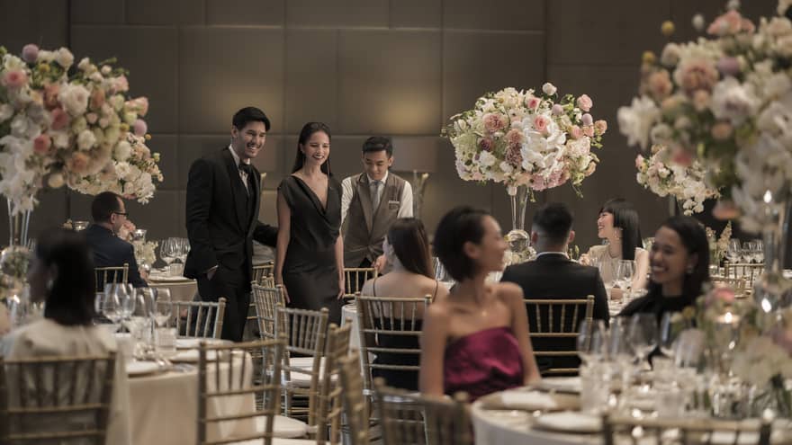 People dressed in elegant formal attire at wedding reception banquet