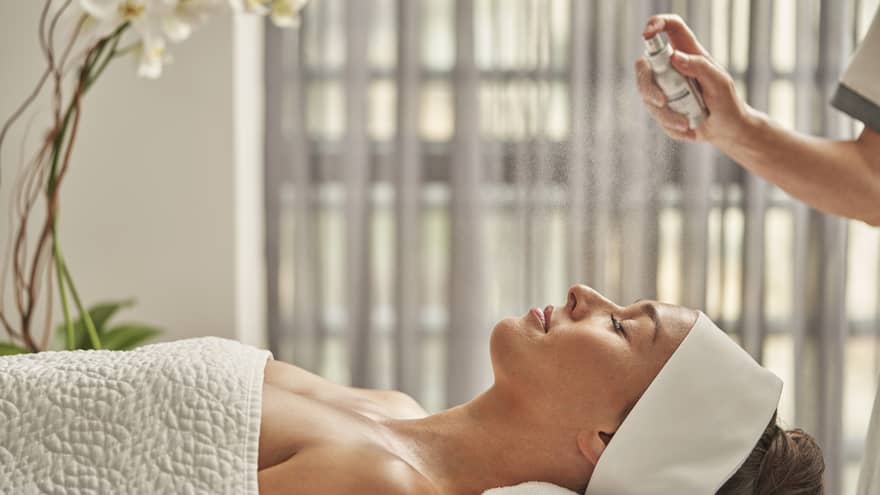 A woman being sprayed with mist during a spa treatment.