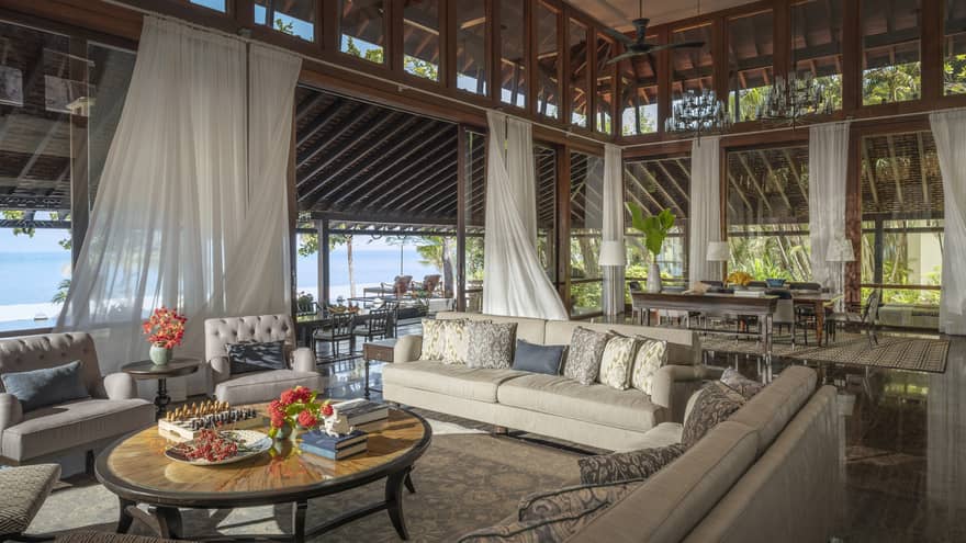 Vast indoor-outdoor living room and great room with high ceilings, flowing white curtains, beach view