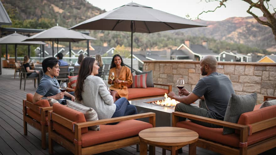 A group of people sitting outside with glasses of wine.