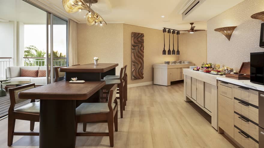 Self-serve counter and two dining tables of different heights in an executive club lounge at resort