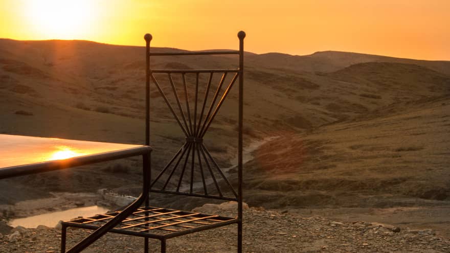 Corner of table, chair in desert at sunset