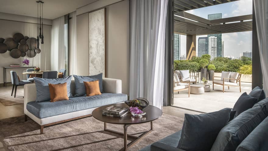 Hotel suite's living room opening up to a terrace with outdoor seating