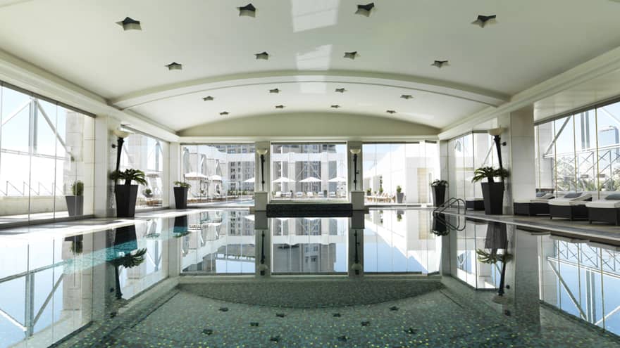 A long shot of a blue pool with mosaic tile.